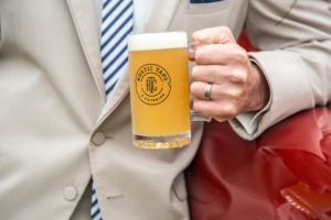 Man with wedding ring holding a Rustic taps pint glass