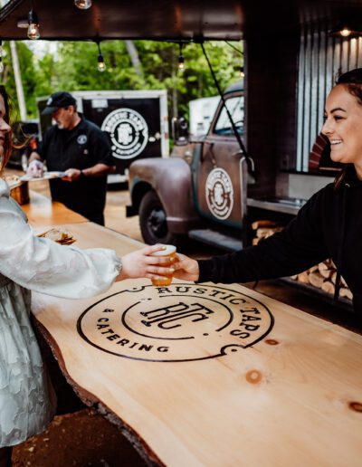 Employee handing wedding guest a beer